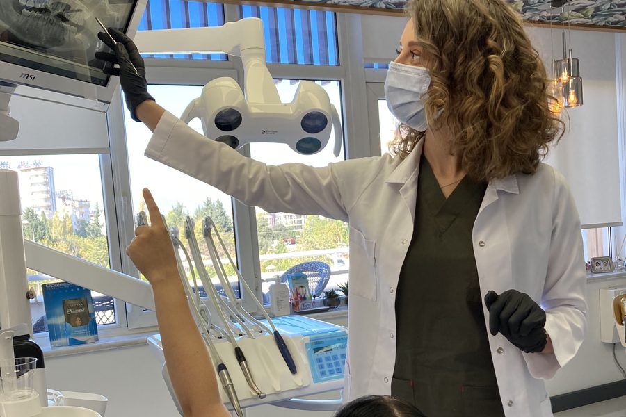 Dr. Dt. Tuba Akcakus Battal reviewing All-on-6 implant X-ray with patient