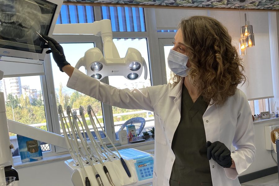 Dr. Dt. Tuba Akcakus Battal reviewing dental implant X-ray with patient